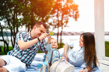 Young happy parents playing with little son outdoor in the parkの写真素材