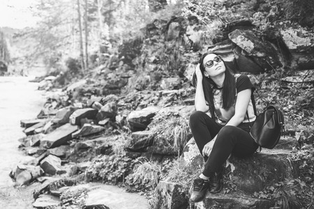 Tourist girl enjoy nature near mountain river, black and whiteの写真素材