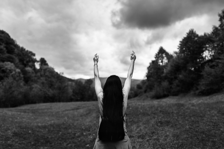 Woman with backpack in the mountains with cloudy sky, black and whiteの写真素材