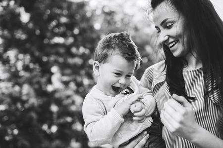 Young mother with her little son outdoor in the park, black and whiteの写真素材