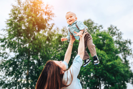 Young happy mother with her little son playing outdoorの写真素材