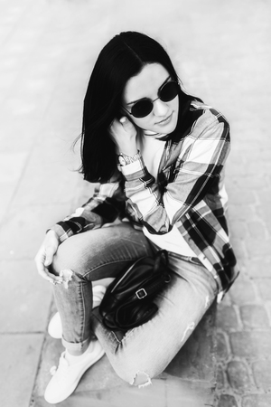 Pretty brunette girl relaxing on the city street, black and whiteの写真素材