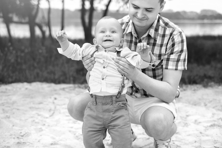Young father with his little son have fun outdoor in the park, black and whiteの写真素材