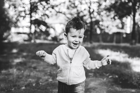 Pretty little boy playing outdoor in the park, black and whiteの写真素材