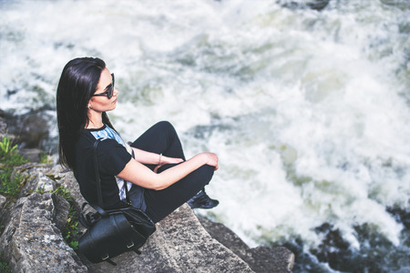 Tourist girl enjoy nature near mountain riverの写真素材