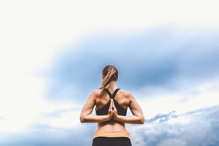Pretty sporty girl showing stretching exercises outdoorの写真素材