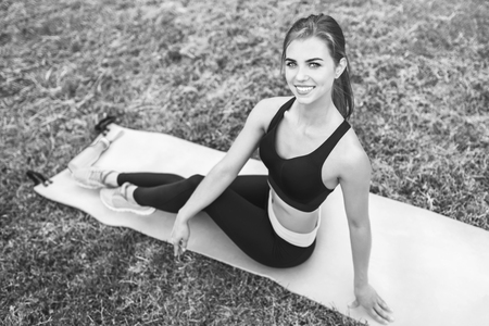 Pretty young sporty girl relaxing after outdoor training, black and whiteの写真素材