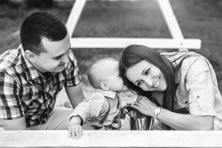Young happy parents playing with little son outdoor in the park, black and whiteの写真素材