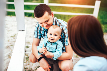 Young happy parents playing with little son outdoor in the parkの写真素材