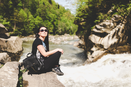 Tourist girl enjoy nature near mountain riverの写真素材