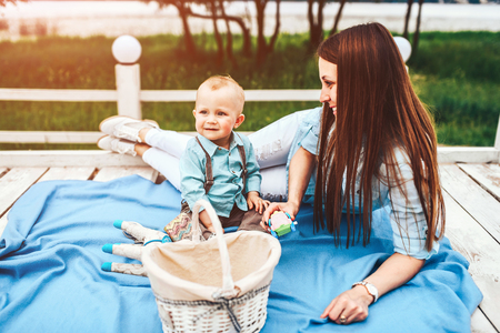 Young happy mother with her little son playing outdoorの写真素材