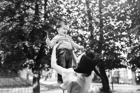 Young mother with her little son outdoor in the park, black and whiteの写真素材
