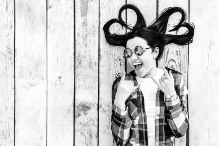Pretty brunette girl on wooden background with place for your text, black and whiteの写真素材