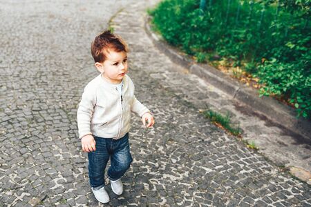 Cute little boy walking alone on the streetの写真素材