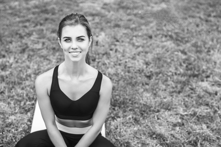 Pretty young sporty girl relaxing after outdoor training, black and whiteの写真素材