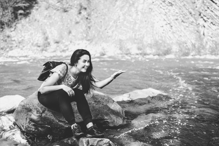 Tourist girl enjoy nature near mountain river, black and whiteの写真素材