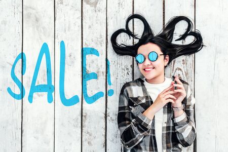 Girl on wooden background with ''sale'' word on itの写真素材