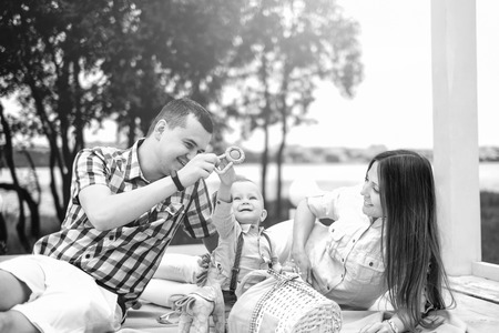 Young happy parents playing with little son outdoor in the park, black and whiteの写真素材