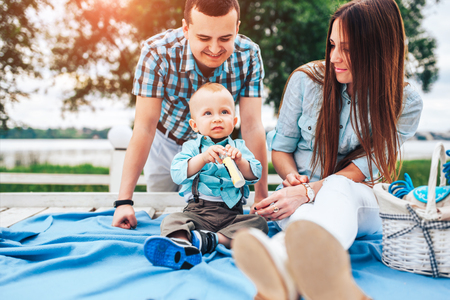 Young happy parents playing with little son outdoor in the parkの写真素材