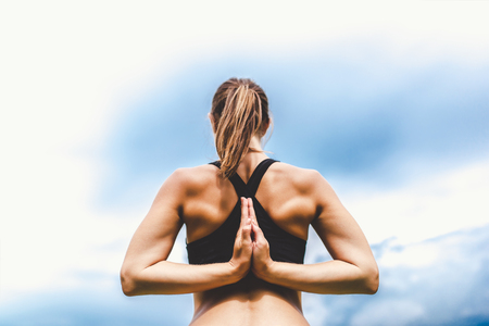 Pretty sporty girl showing stretching exercises outdoorの写真素材