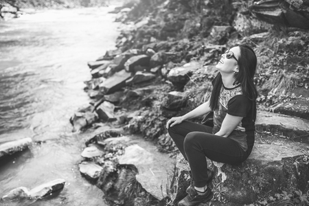 Tourist girl enjoy nature near mountain river, black and whiteの写真素材