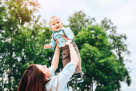 Young happy mother with her little son playing outdoorの写真素材