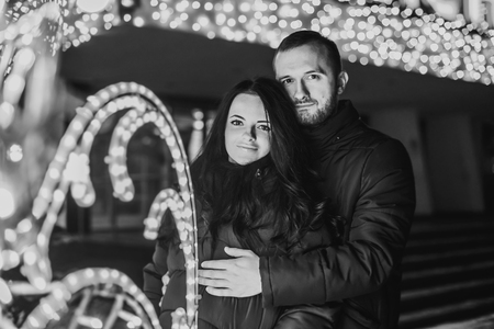 Pretty couple in love with christmas lights behindの写真素材