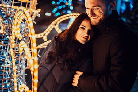 Pretty couple in love with christmas lights behindの写真素材