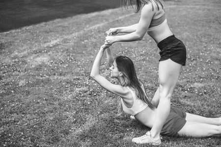 Two pretty sporty girls workout together outdoor, black and whiteの写真素材