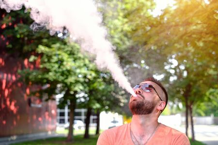 Vaper with beard with electronic cigarette outdoorの写真素材