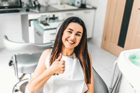 Happy dental patient in the dental chairの写真素材