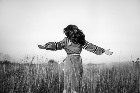 Pretty brunette girl in long embroidery dress outdoorの写真素材