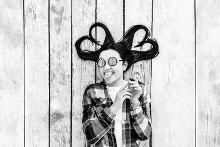 Pretty brunette girl on wooden background with place for your text, black and whiteの写真素材