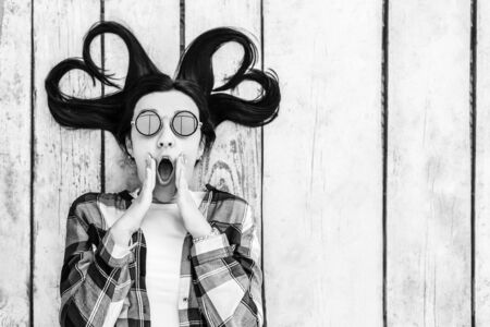 Pretty brunette girl on wooden background with place for your text, black and whiteの写真素材