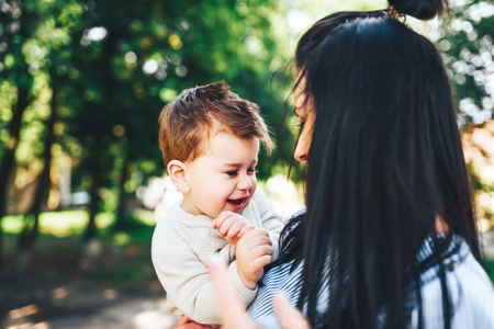 Young mother with her little son outdoor in the parkの写真素材