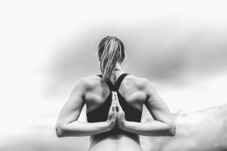 Pretty sporty girl showing stretching exercises outdoor, black and whiteの写真素材