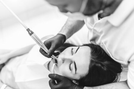 Dentist working in dental clinic with patient in the chairの写真素材