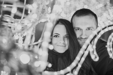 Pretty couple in love with christmas lights behindの写真素材