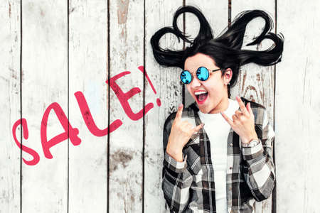 Girl on wooden background with ''sale'' word on itの写真素材