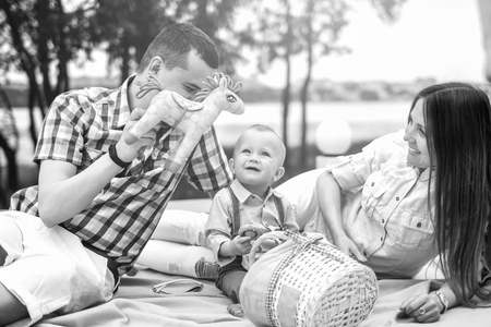Young happy parents playing with little son outdoor in the park, black and whiteの写真素材