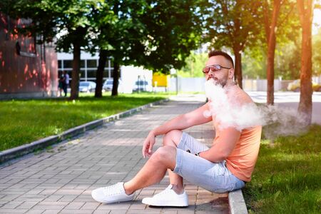 Vaper with beard with electronic cigarette outdoorの写真素材