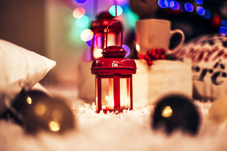 Christmas lantern with candle on colorful bokeh backgroundの写真素材