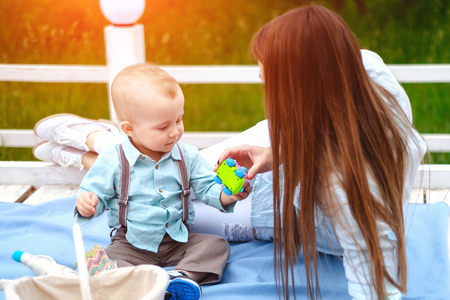 Young happy mother with her little son playing outdoorの写真素材