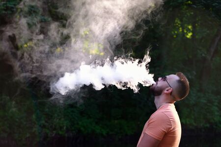 Vaper with beard with electronic cigarette outdoorの写真素材