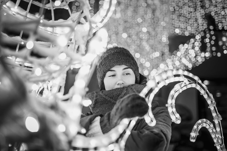 Girl outdoor in cold weather with christmas lights behindの写真素材