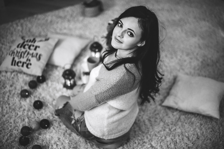 Happy pregnant woman at home with christmas decorationsの写真素材