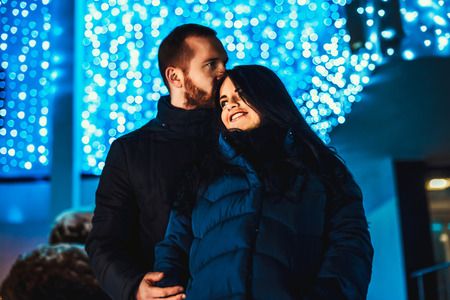 Pretty couple in love with christmas lights behindの写真素材