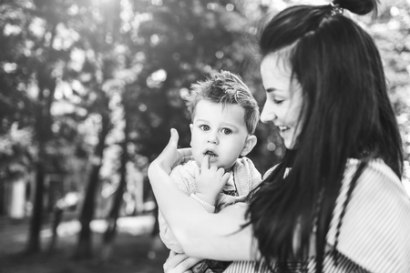 Young mother with her little son outdoor in the park, black and whiteの写真素材