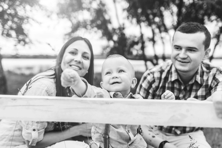 Young happy parents playing with little son outdoor in the park, black and whiteの写真素材