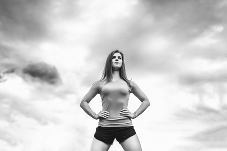Sporty young fitness coach girl with sky on background, black and whiteの写真素材